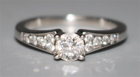A modern 18ct white gold and single stone diamond ring with diamond set shoulders, size I.